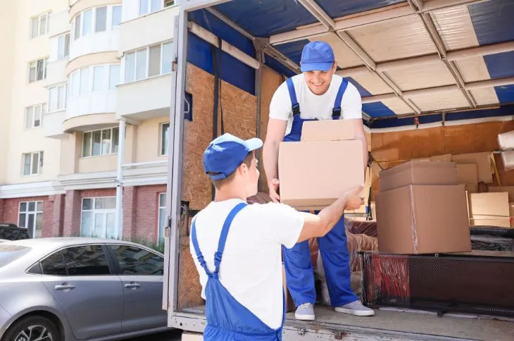 Umzugshelfer entladen Kartons aus LKW